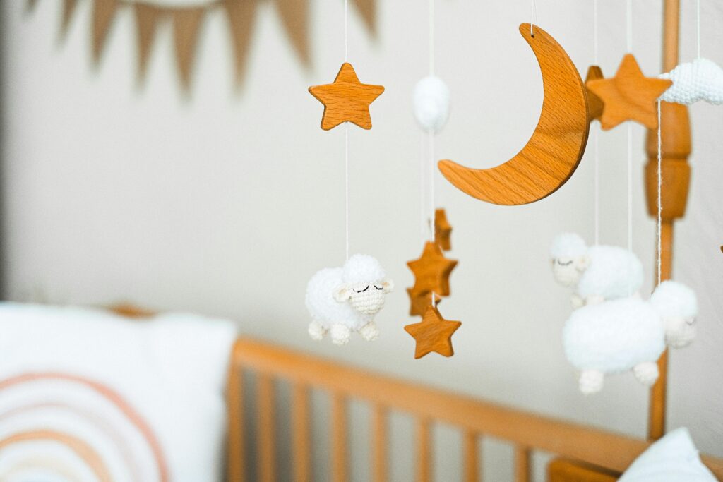 Static in the Baby Monitor Wooden crib mobile featuring stars, a crescent moon, and fluffy sheep for a cozy baby nursery.